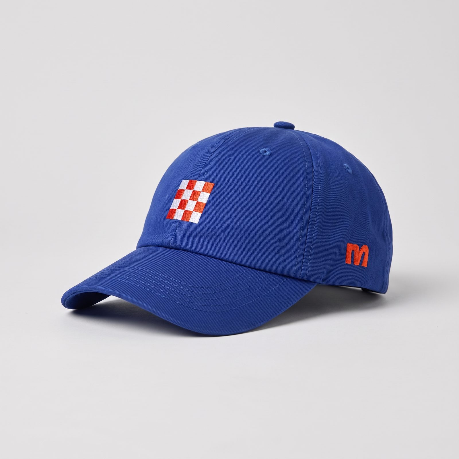 The cobalt cap with the red and white checker patch on the front and an orange letter on the side