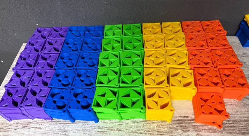 Rows of 3D-printed charms in purple, blue, green and yellow