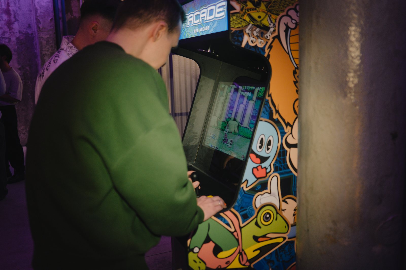 A guest playing an arcade machine