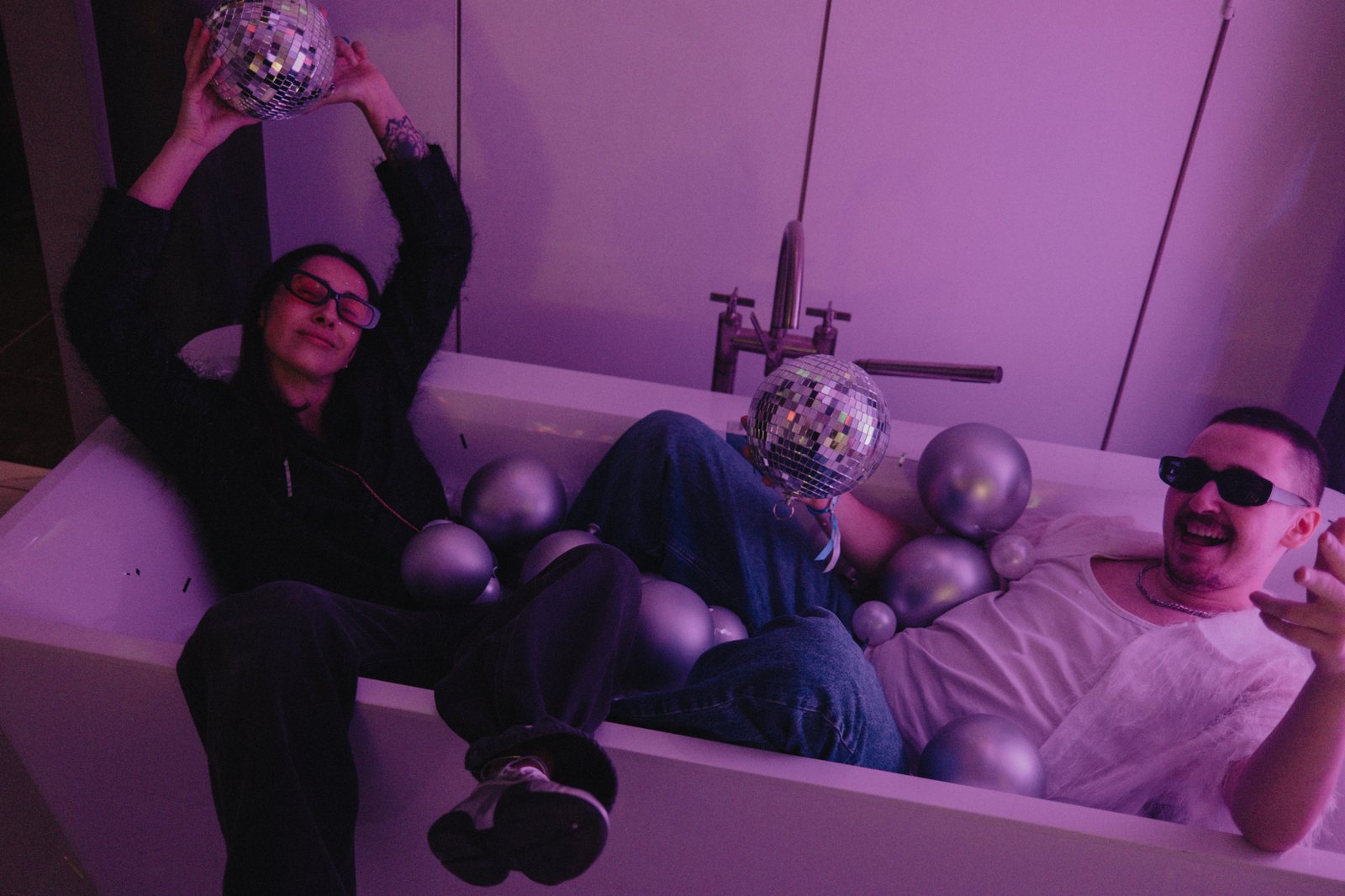 Two guests in the disco bath full of silver balls