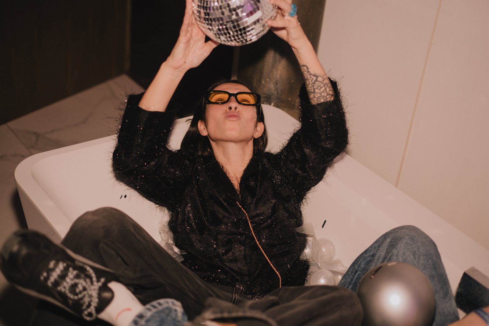 Holding a disco ball up in the bath
