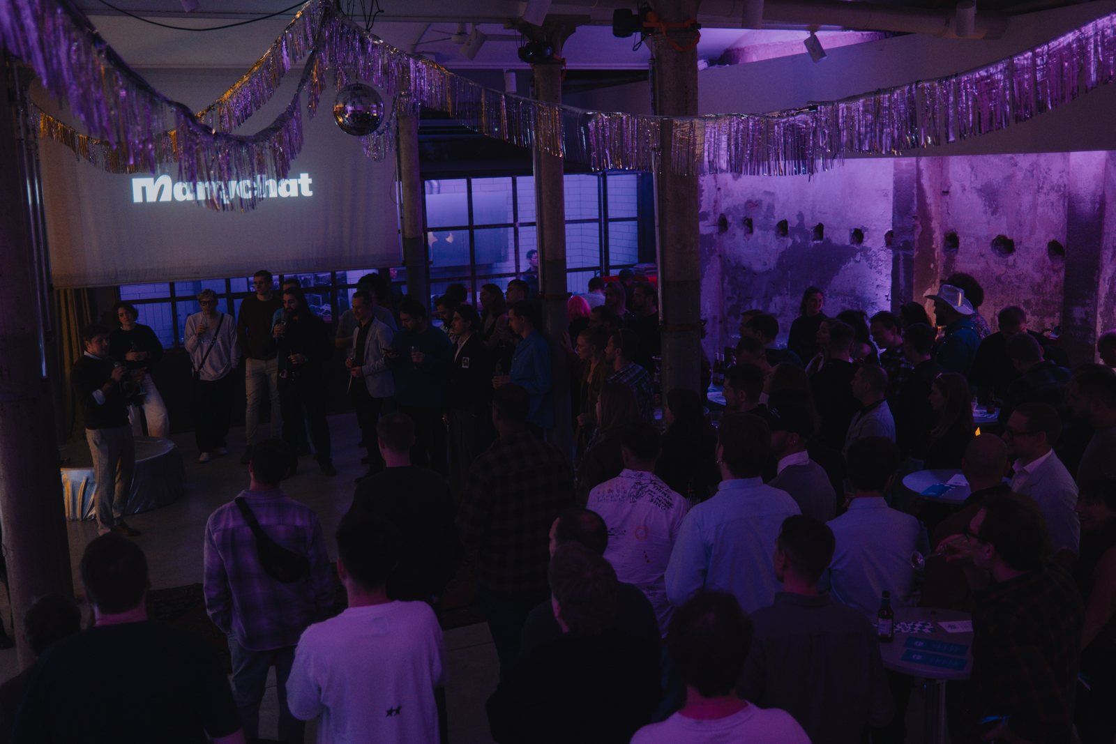 Guests in ultraviolet light under silver tinsel