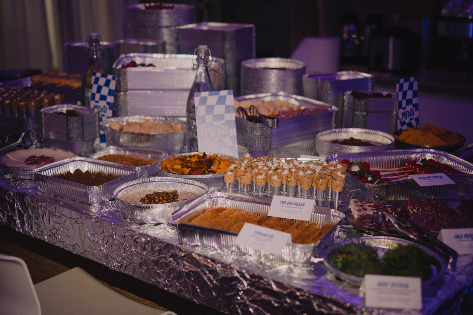Food in silver trays on a foil-covered table