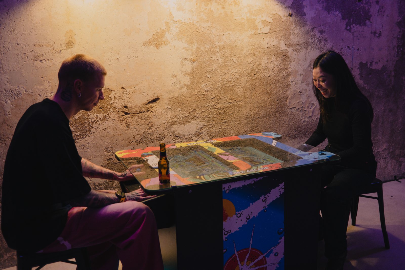 Two guests playing at a table arcade