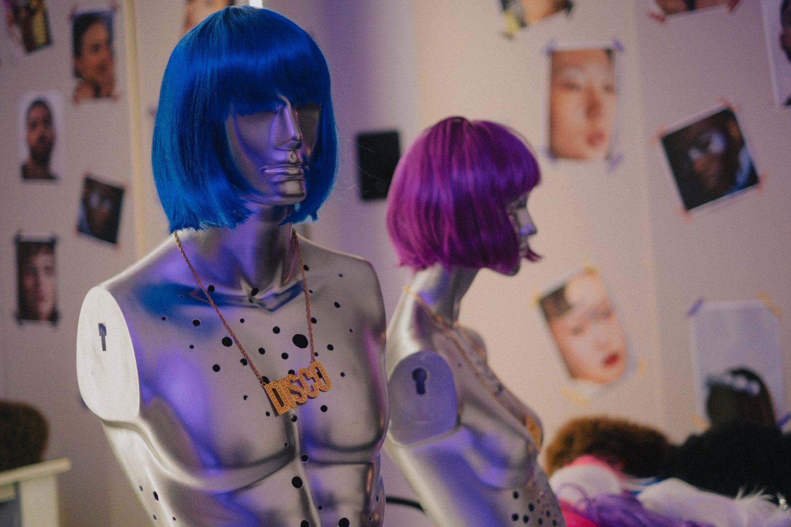 Silver mannequin busts in blue and purple wigs