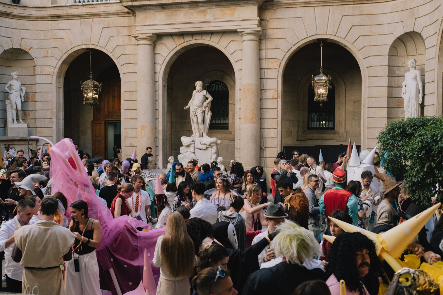 The courtyard full of guests in costume holding up their creatures