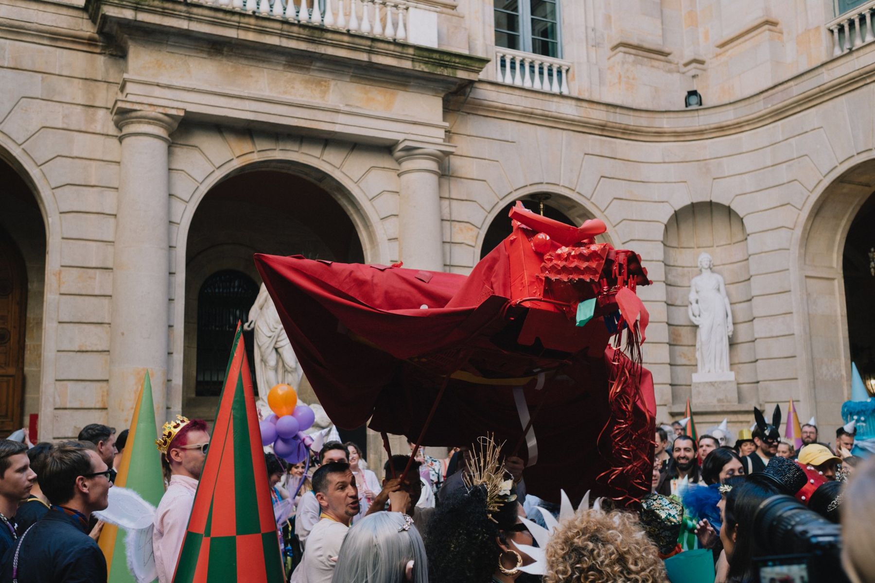 A big red dragon built by a team, carried over the crowd