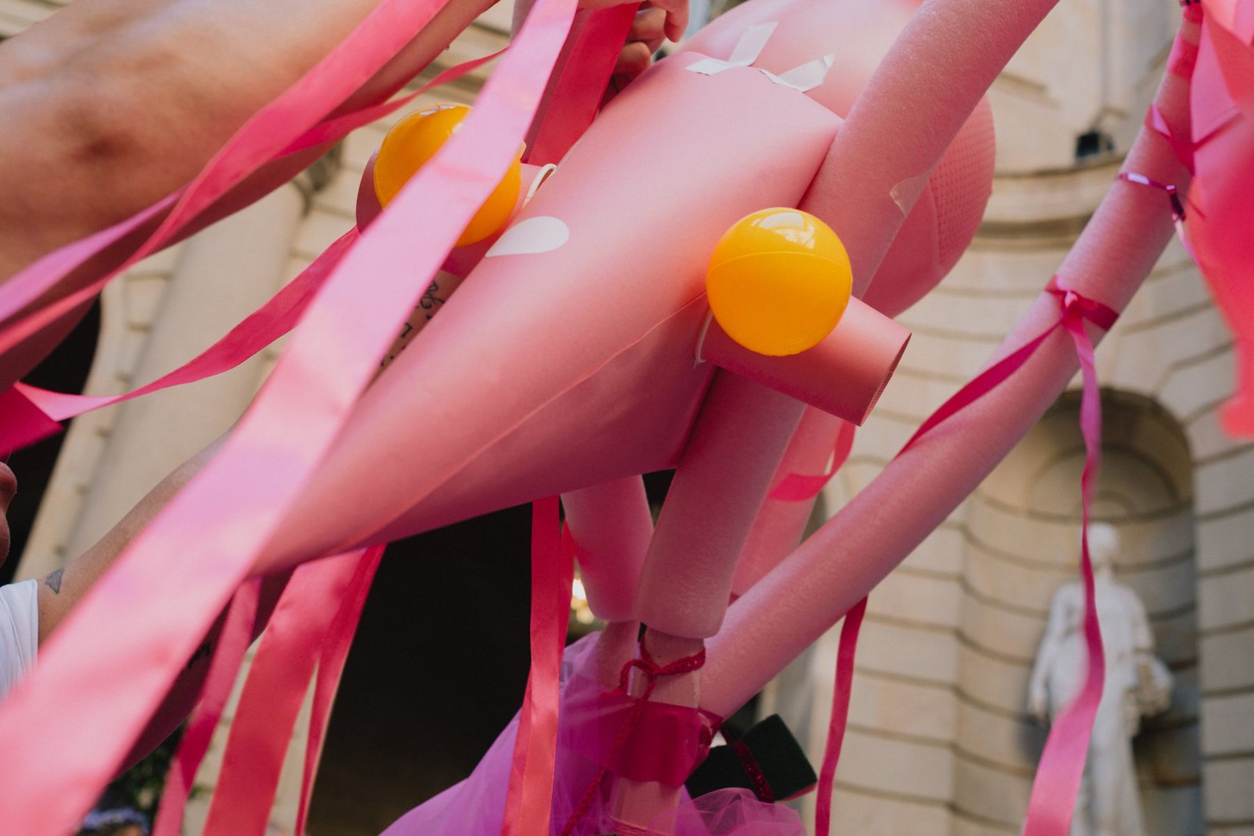 Close-up of the pink creature's ribbons and orange eyes
