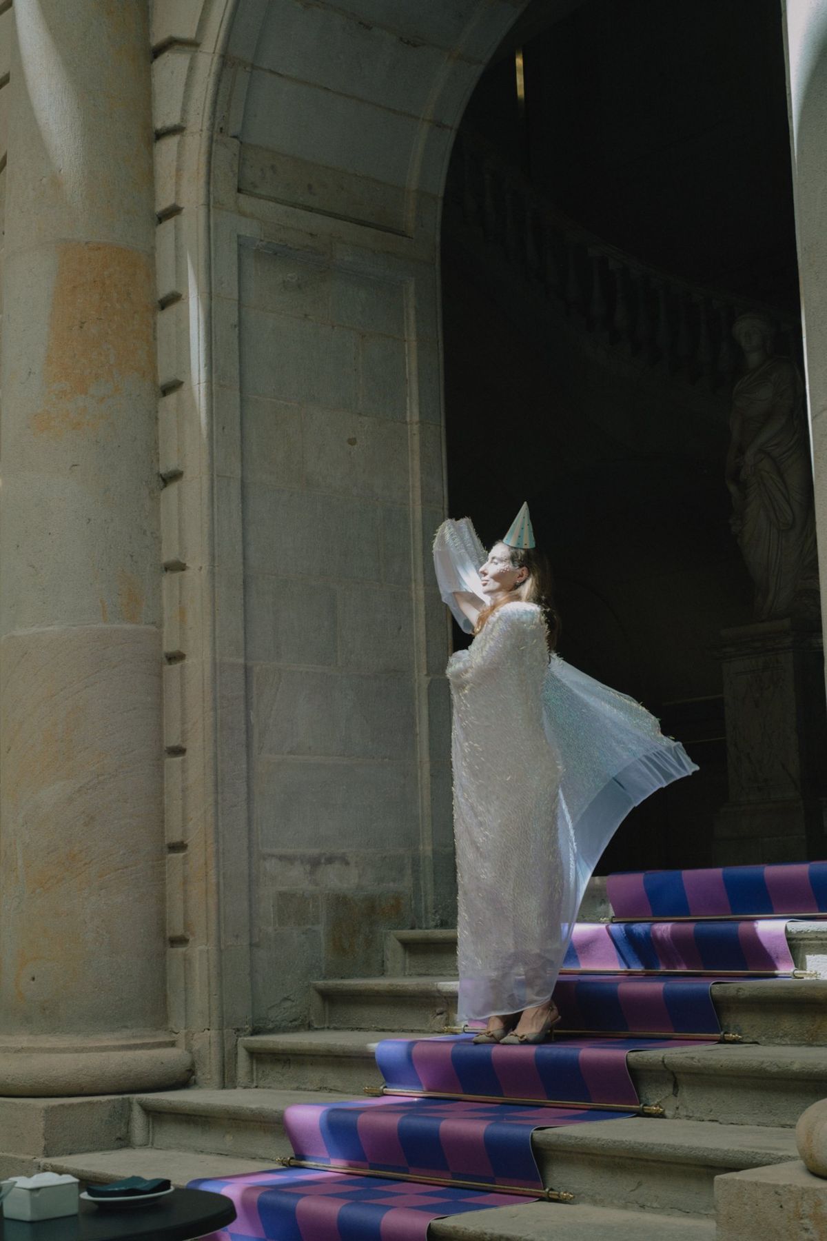 A figure in a white robe on the checkered stairs