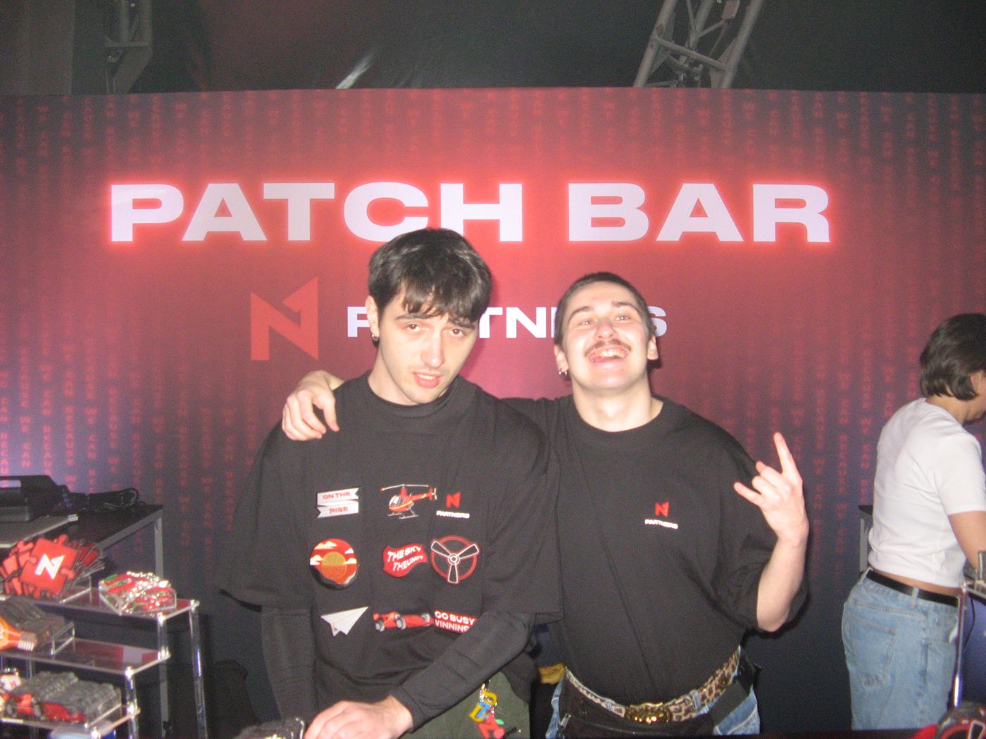 Two crew members under the Patch Bar sign