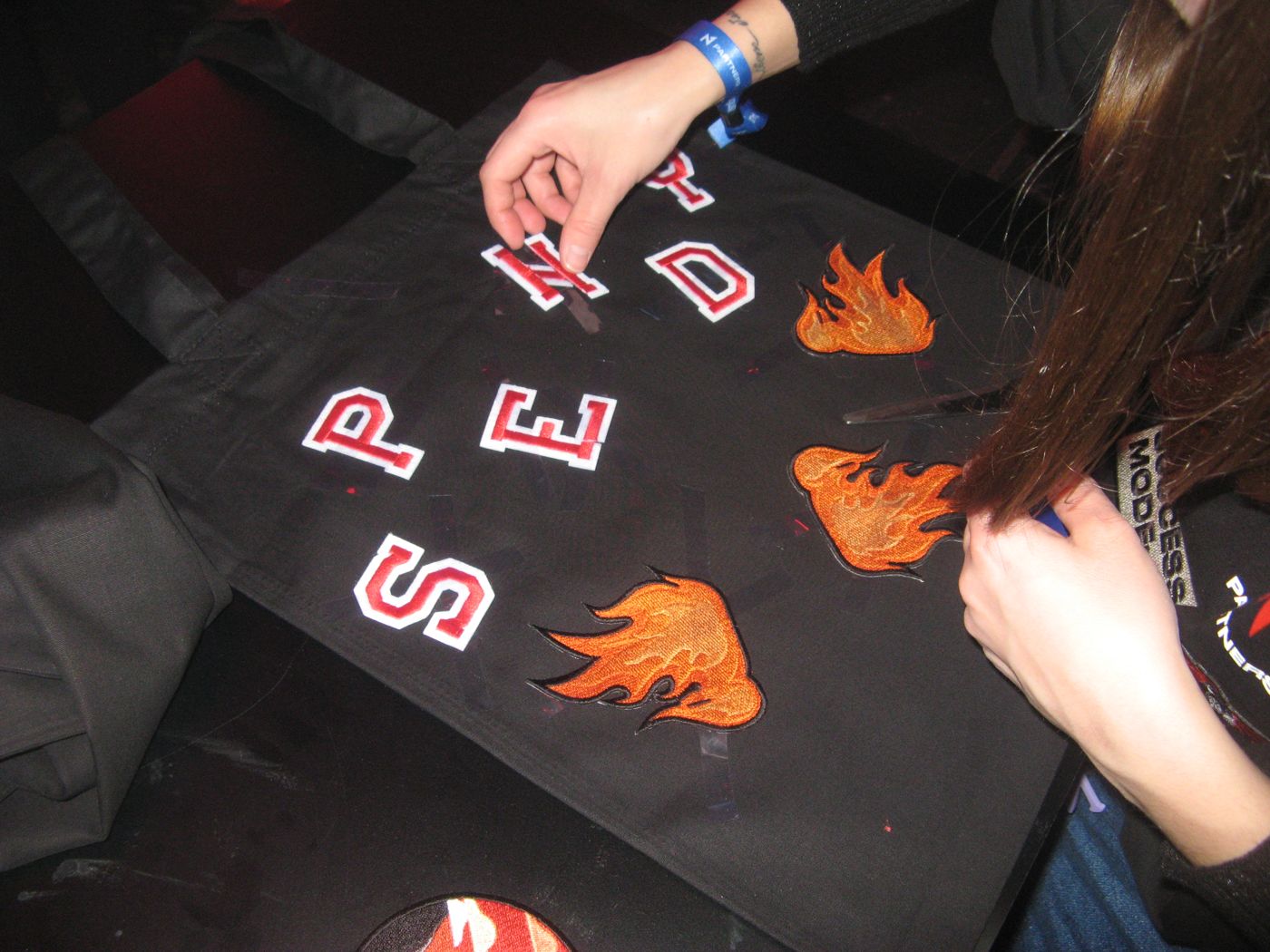 Letters and flames laid out on a tee before pressing
