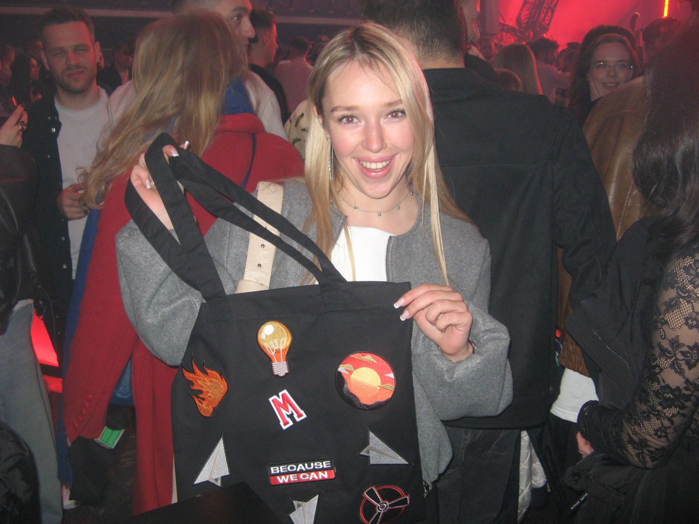 A guest with a tote, a lamp patch and an M