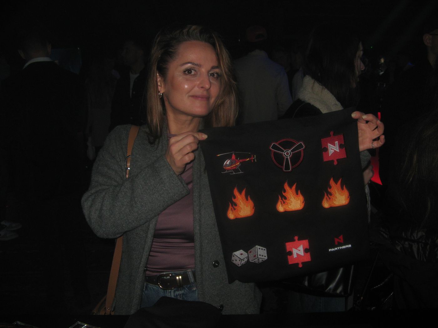 A guest holding a tote with three flames and a helicopter