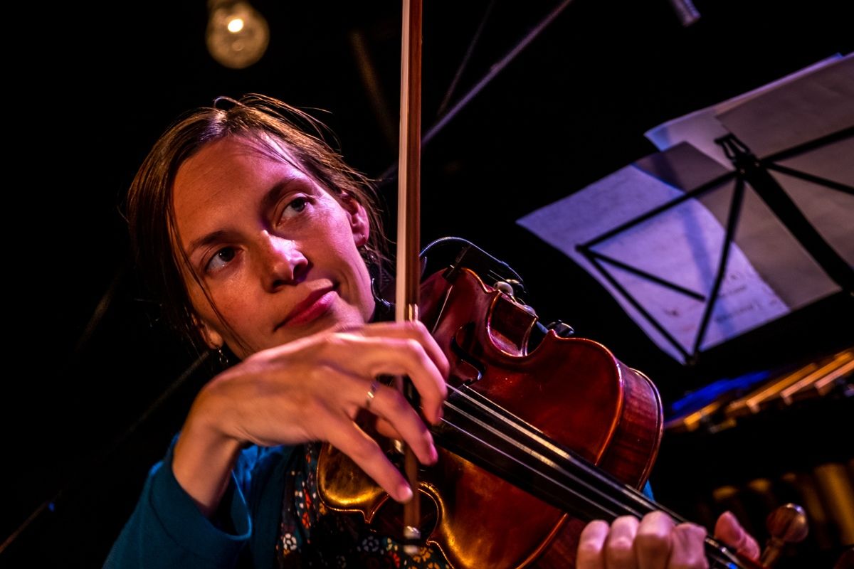 A violinist from the orchestra playing on stage