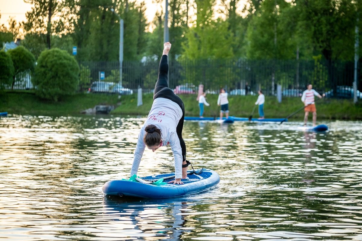 A surfer doing a handstand on a paddle board